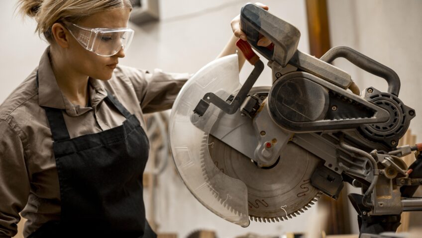 A woman confidently operating a miter saw on a construction site, illustrating why women should work in construction